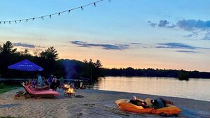 A lakeside setting with lounge chairs, a fire pit, and string lights. - Christie's Mill Inn & Spa, BW Premier Collection (Georgian Bay)