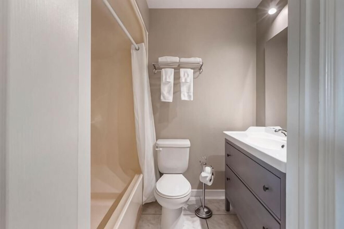 A bathroom with a toilet, sink, and shower.