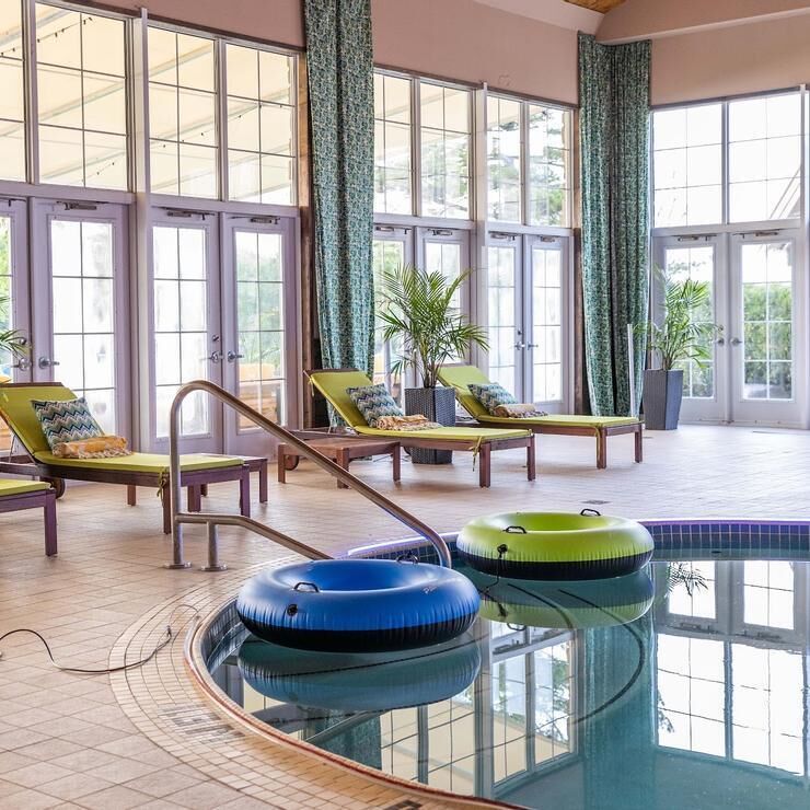 Una piscina techada, sillones reclinables de piscina