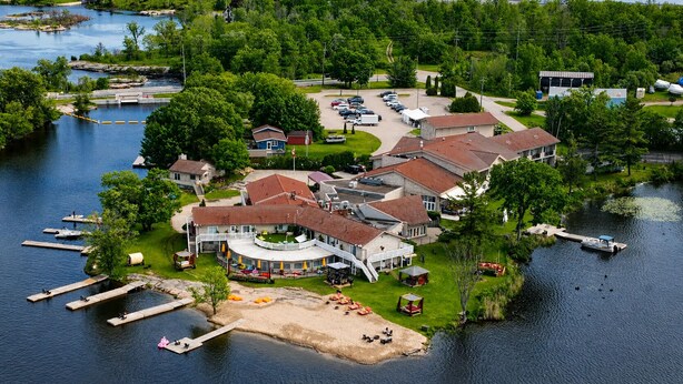 A lakeside property with a large house, dock, and boat. - Christie's Mill Inn & Spa, BW Premier Collection (Georgian Bay)