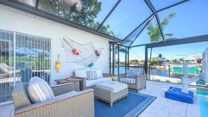 Katettu ulkoalue, jossa on rottingista valmistettuja huonekaluja, uima-allas ja näkymä ympäröivään maisemaan.