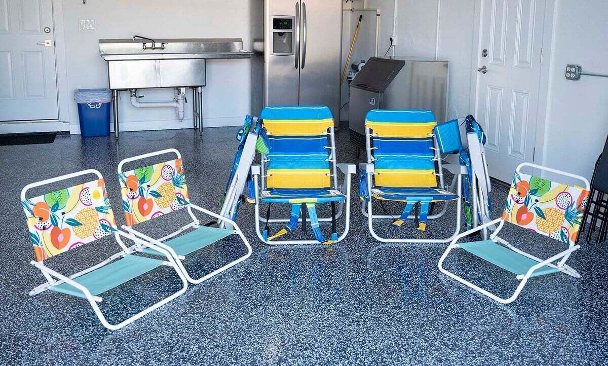 Un coin cuisine équipé d’un réfrigérateur en acier inoxydable, d’un évier et d’une poubelle bleue.