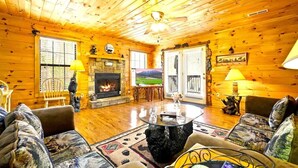 Ein gemütliches Blockhaus-Interieur mit Kamin, Holzwänden und einer einladenden Sitzecke.
