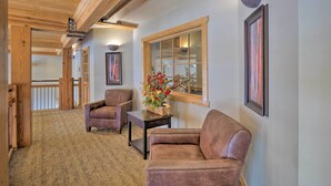 A spacious living area with a high ceiling, wooden beams, a large window, and a fireplace. - Fantastic New Years Week Ski-In and Ski-Out Grand Timber Lodge Breckenridge, CO (Breckenridge)