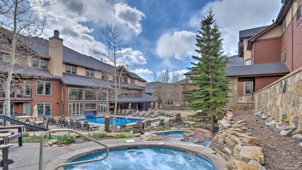A hotel with a swimming pool, outdoor seating, and a stone wall. - Fantastic New Years Week Ski-In and Ski-Out Grand Timber Lodge Breckenridge, CO (Breckenridge)