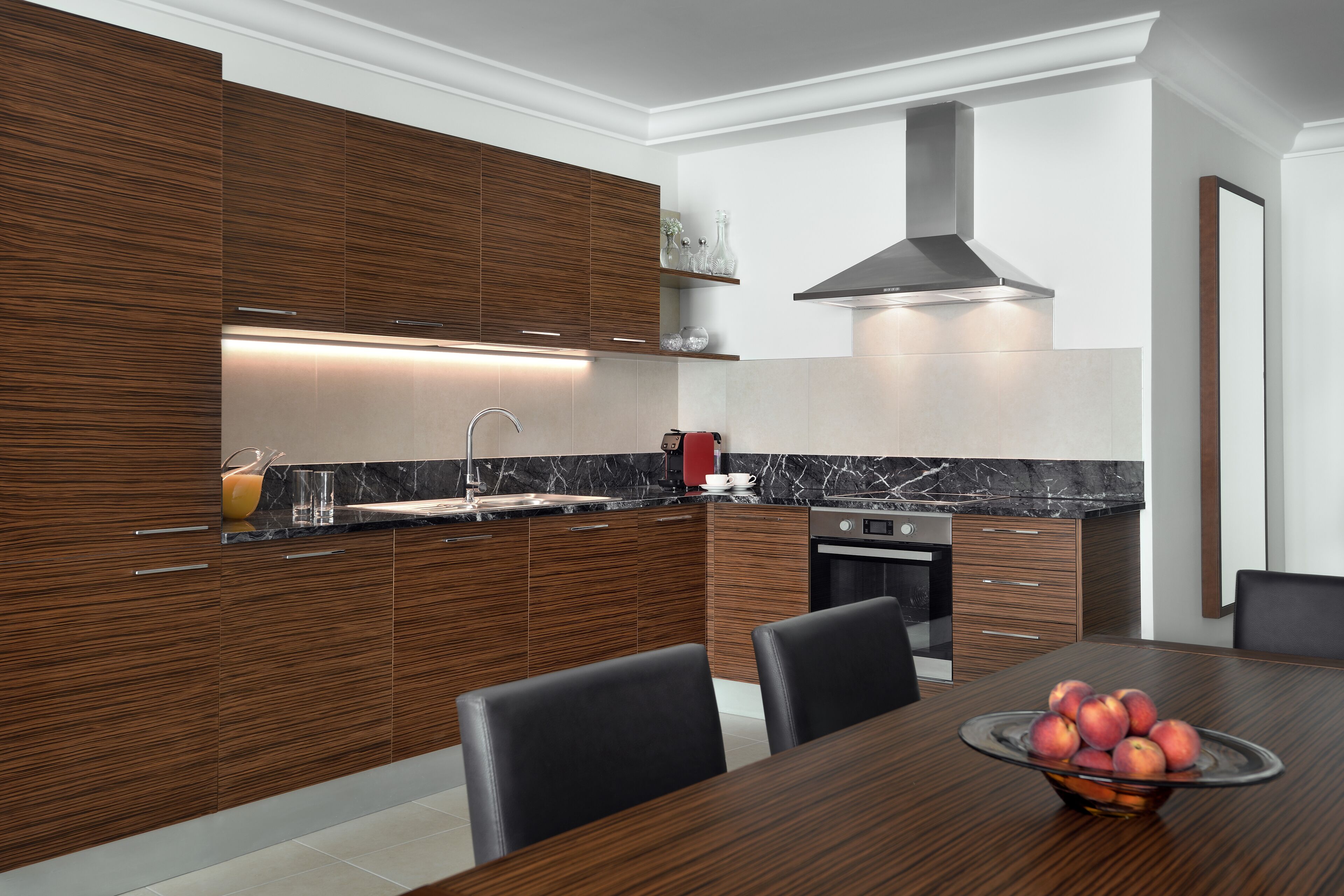 Une cuisine moderne avec des meubles en bois, une hotte en acier inoxydable et un plan de travail en marbre.