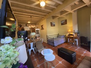 A cozy living room with a bed, dining table, and chairs. There is a kitchen area in the background. - Hermoso Apartamento en Marcala (Marcala)