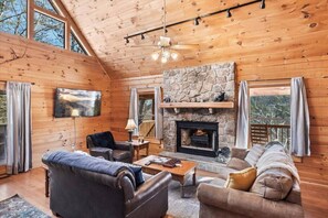 Cozy living room with a fireplace, comfortable seating, and a wall-mounted TV.
