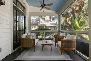 Relax on the porch with a view of lush greenery and palm trees.
