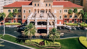 A large hotel with a central courtyard, multiple parking levels, and surrounding palm trees. - Westgate Vacation Villas (Kissimmee)