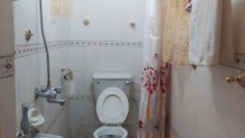 A small bathroom with a toilet, sink, and shower curtain.