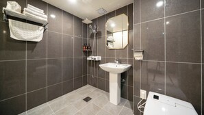 Une salle de bain moderne équipée d’une douche, d’un lavabo et d’un porte-serviettes.