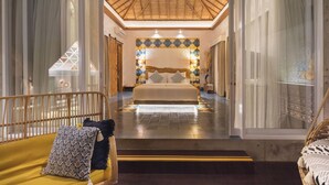 Une chambre d’hôtel avec un grand lit, un plafond en bois et un mur orné de motifs.