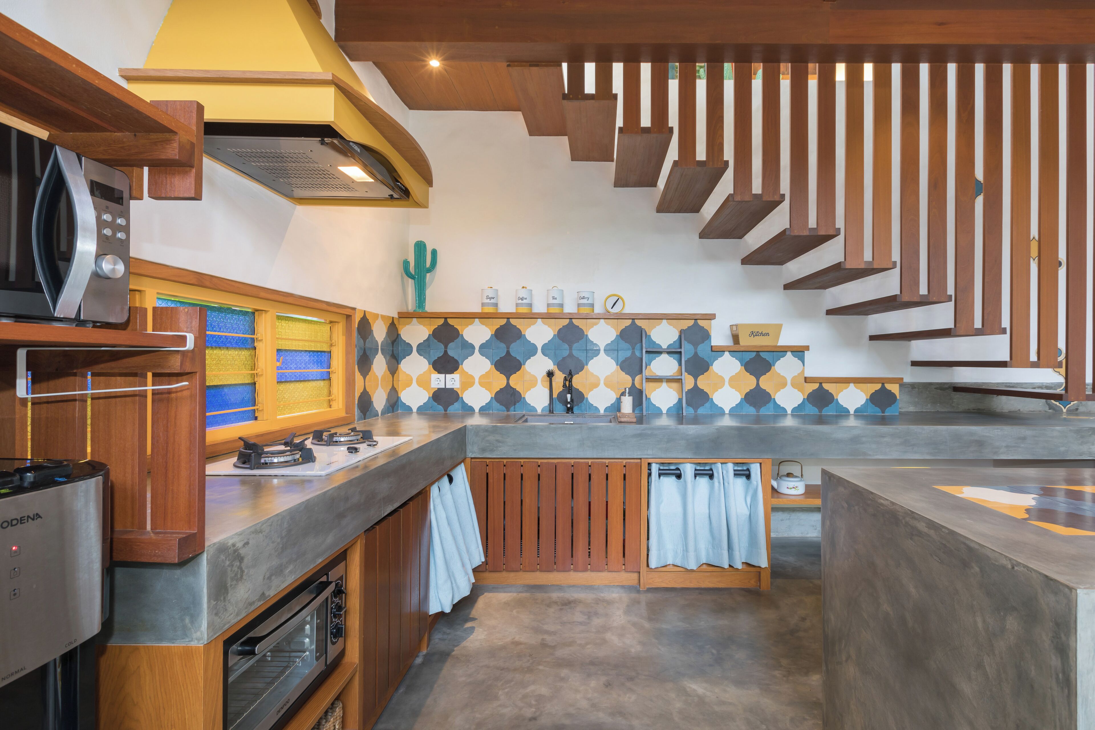 Una cocina moderna con horno empotrado, microondas y armarios de madera.