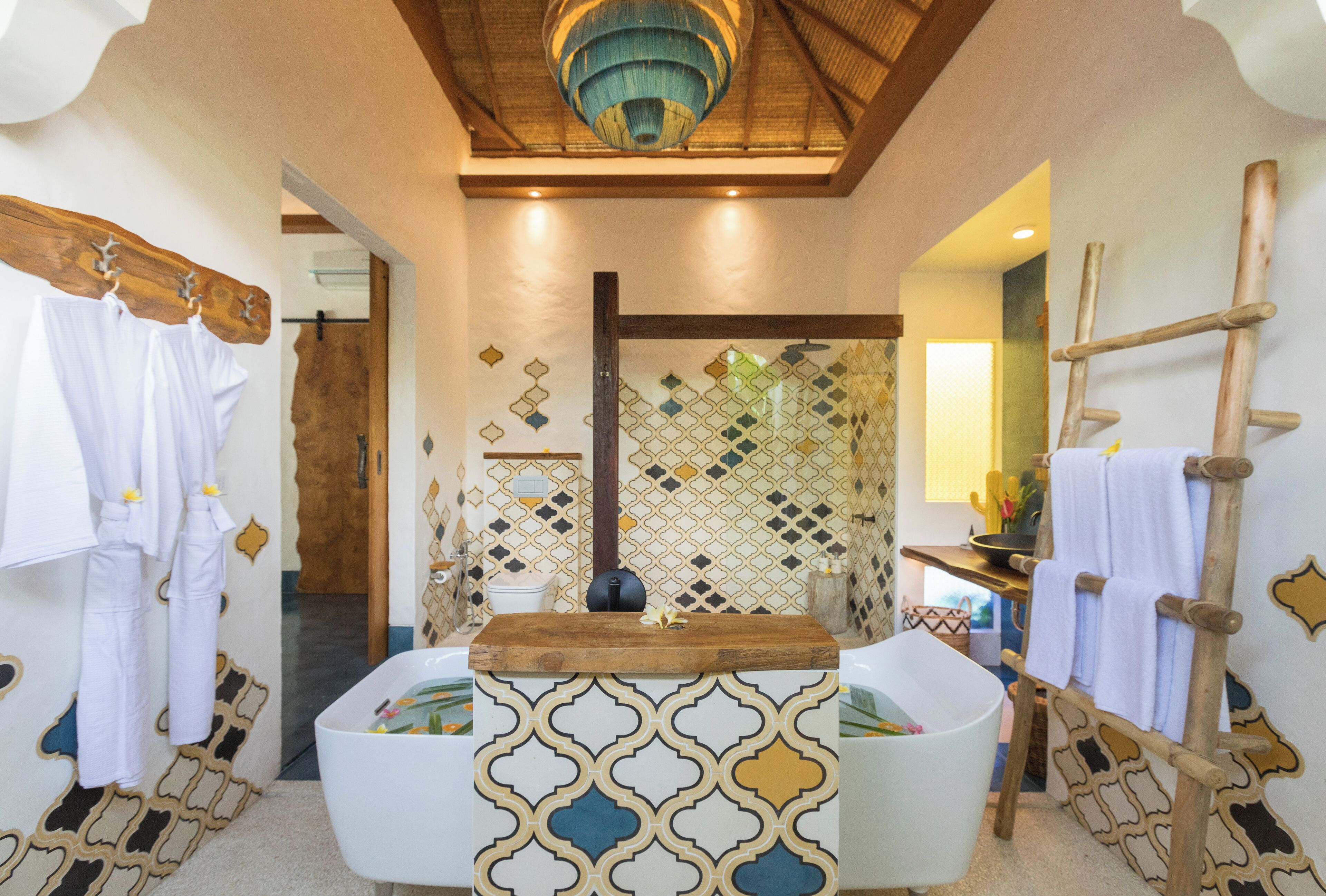 Ein Badezimmer mit Badewanne, einem Holzkosmetikschrank und Handtüchern auf Ablagen.