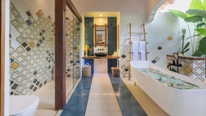 Une salle de bain avec un mur à motifs, un lavabo avec un miroir, une baignoire et un espace douche.