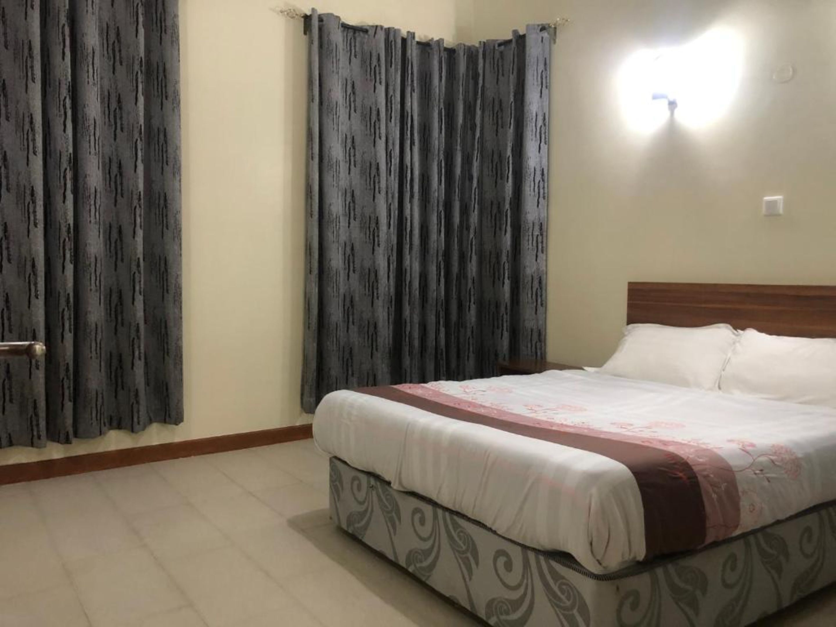 A bedroom with a bed, curtains, and a nightlight.