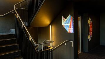 A staircase with metal railings and a wall-mounted light.