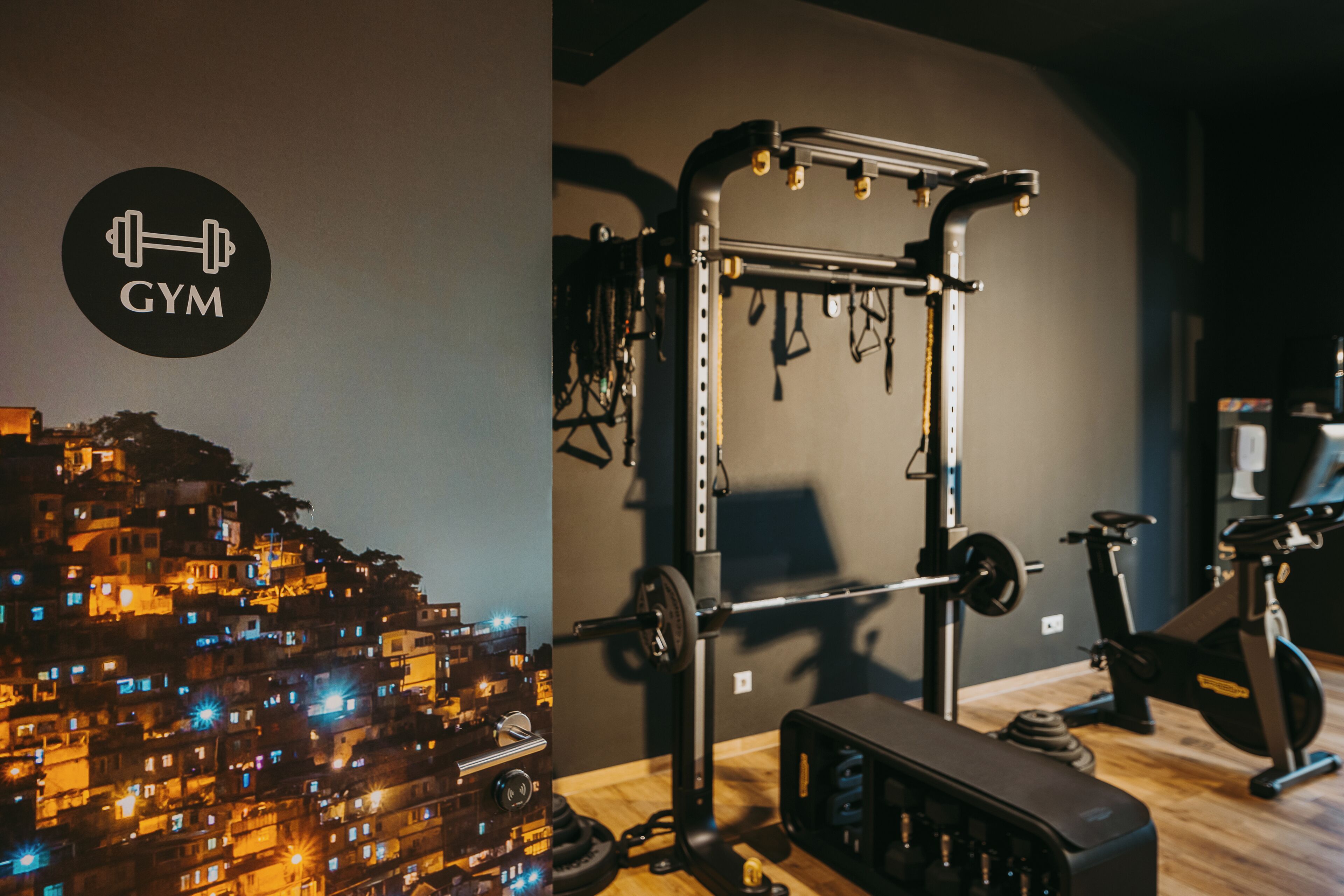 A gym with a squat rack, barbell, and weight plates.