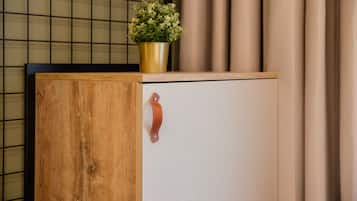 A wooden cabinet with a metal handle and a potted plant on top.
