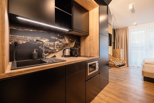 A modern kitchen with a cityscape backsplash, a built-in oven, and a wooden countertop. - Rioca Stuttgart Posto 4 (Stuttgart)