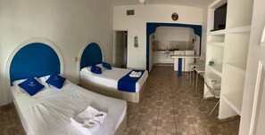 A hotel room with two beds, a kitchenette, and a dining area. - Hotel Paraíso Kora (Aticama)