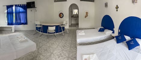Habitación de hotel con dos camas, un escritorio y una silla.