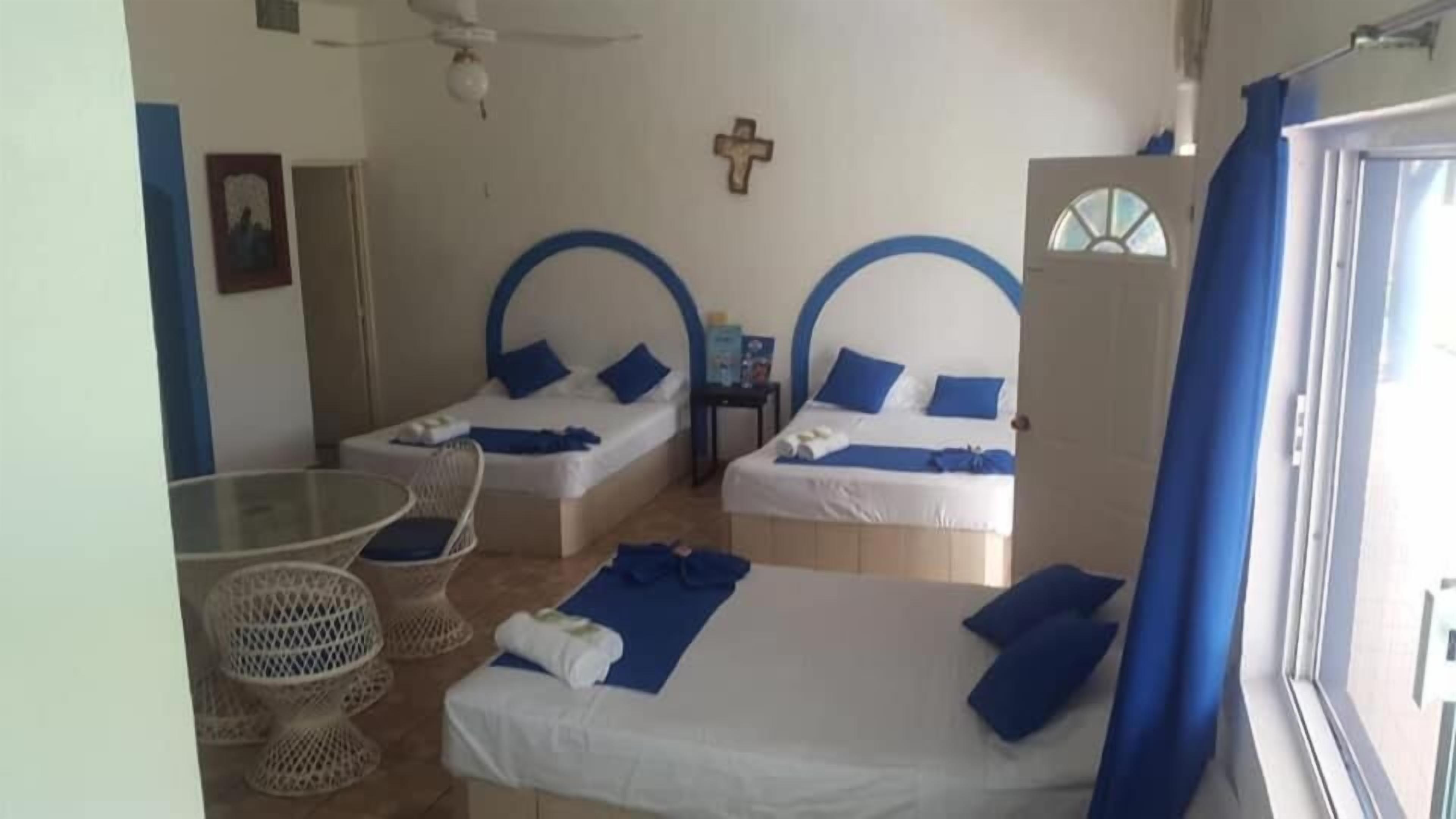 A room with two beds, a small table, and a chair.