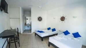 A hotel room with two single beds, a desk, and a chair. - Hotel Paraíso Kora (Aticama)