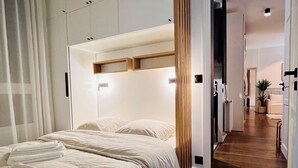 A modern bedroom with a large bed, built-in headboard, and a wooden floor. - ✨ Luxury 2BR - 300m from Eiffel Tower - Rue Cler area (Paris)