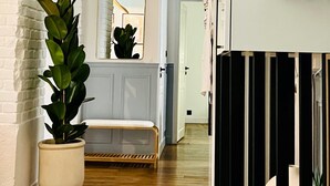 A hallway with a potted plant, a bench, and a mirror on the wall. - ✨ Luxury 2BR - 300m from Eiffel Tower - Rue Cler area (Paris)