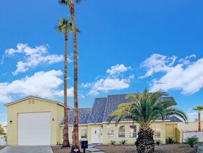 A two-story house with a garage, a sloped roof, and a fenced yard. - "Lake house w/Mountain views” near River & Casinos (Bullhead City)