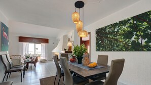 Un comedor con una mesa, sillas y una lámpara colgante.
