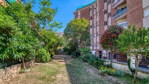 A courtyard with a pathway, greenery, and a brick building with balconies. - Pet-Friendly 'Nice Apartment with Terrace' & Wi-Fi (Lloret de Mar)