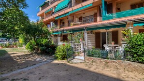 A multi-story building with balconies, outdoor seating, and potted plants. - Pet-Friendly 'Nice Apartment with Terrace' & Wi-Fi (Lloret de Mar)