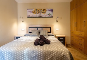 A bedroom with a bed, two bedside tables, a wooden wardrobe, a painting on the wall, and a teddy bear on the bed. - Apartment "Las góndolas playa" with sea views, shared pool and Wi-Fi (Almunecar)