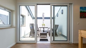 Ein modernes Interieur mit einer Glastür, die zu einer Außenpatio führt.