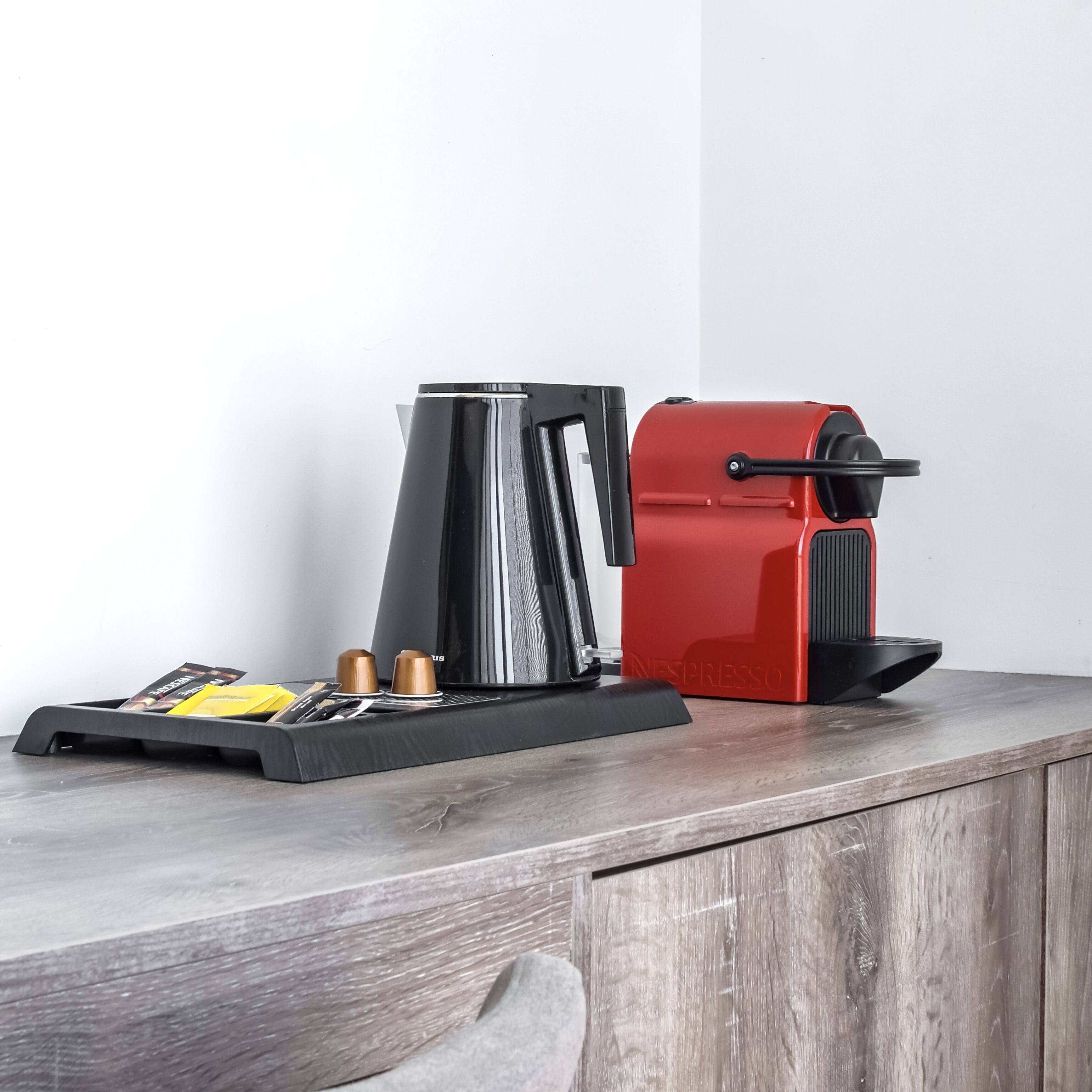 A coffee maker and a kettle on a wooden countertop.