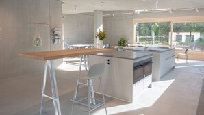 Cocina moderna con una isla central, taburetes de bar y un ventanal con vistas al exterior.