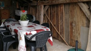 A rustic dining area with a wooden table and chairs, a potted plant, and a green object on the floor. - 2 Bedroom Private vacation home in Soueix-Rogalle (Soueix-Rogalle)