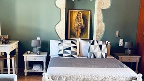 A bedroom with a bed, two nightstands, a dresser, and a painting on the wall. - Skandalis Apartment with pool view (Theano) (CHORAFAKIA CHANIA)
