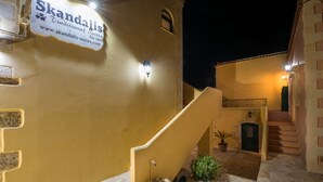 A traditional building with a sign for 'Skandalis' and a staircase leading to a door. - Skandalis Apartment with pool view (Theano) (CHORAFAKIA CHANIA)