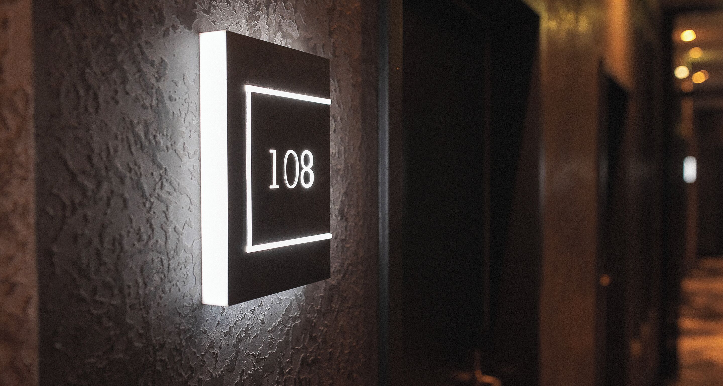 Una targa appesa al muro con il numero 108, che indica una stanza o un luogo.