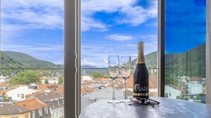 Un balcón con vistas a un pueblo, dos vasos y una botella de Plaza Hotelroaul.