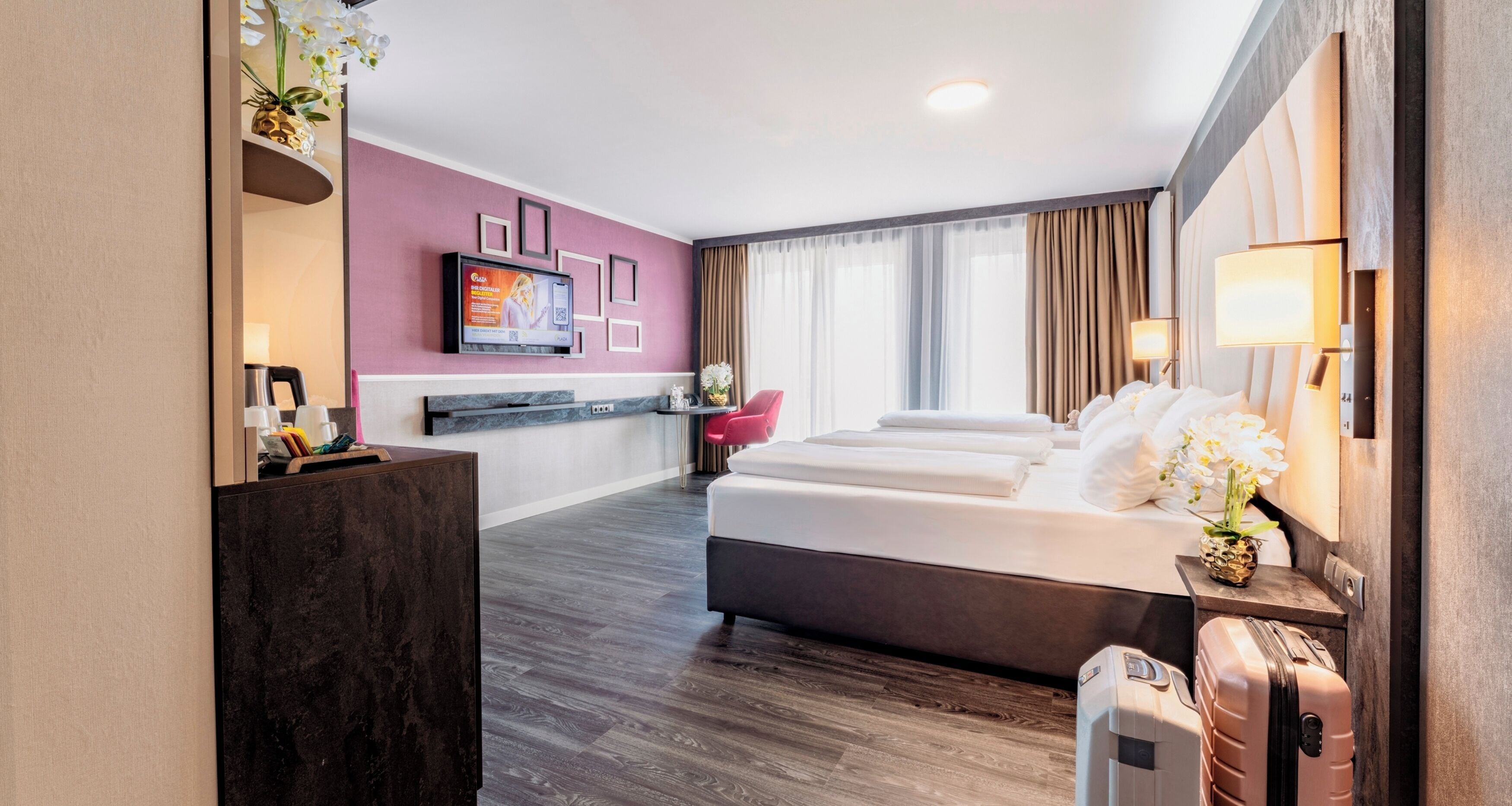 A hotel room with a bed, a desk, a TV, and a bathroom.