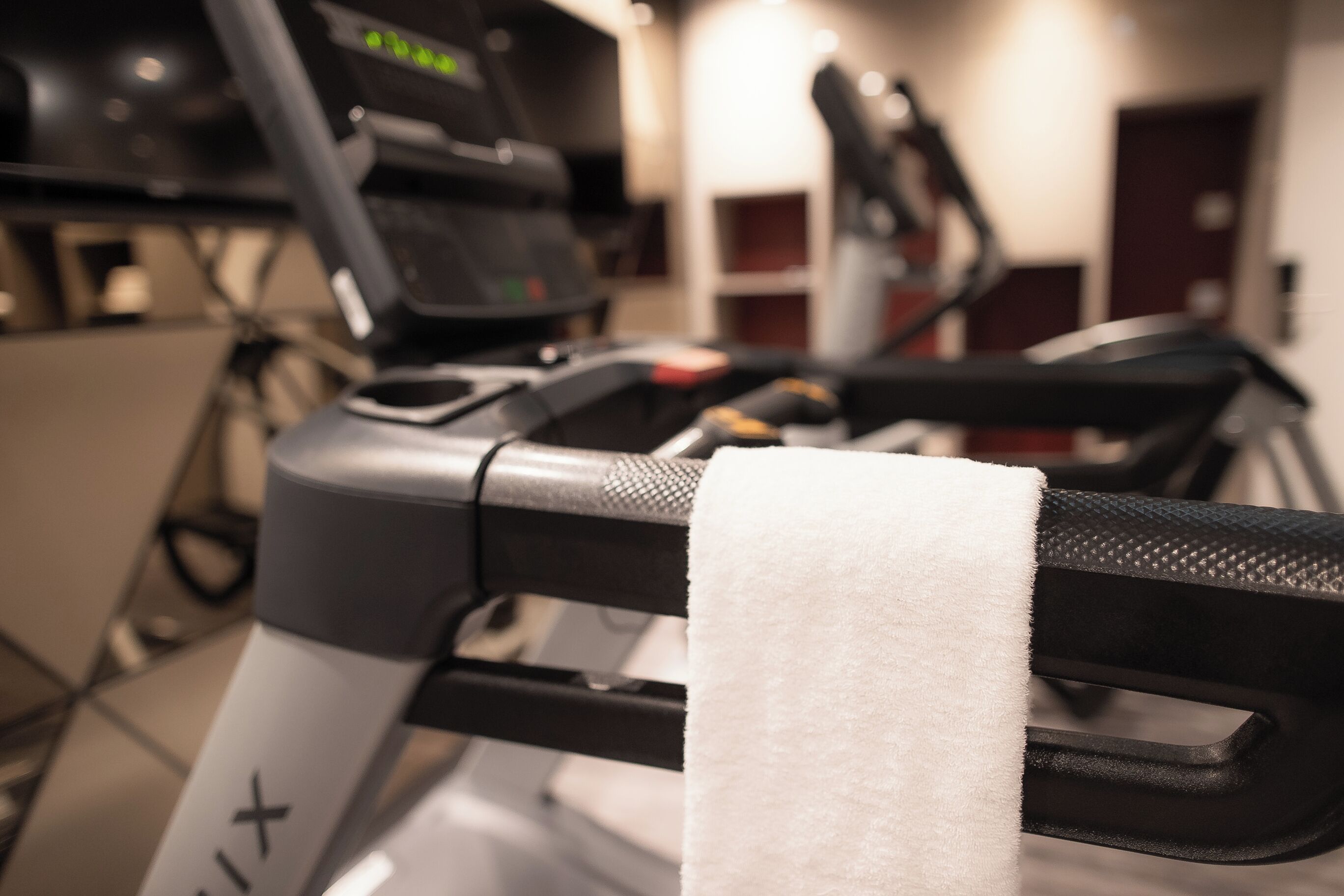 A treadmill with a white towel hanging on the handle.