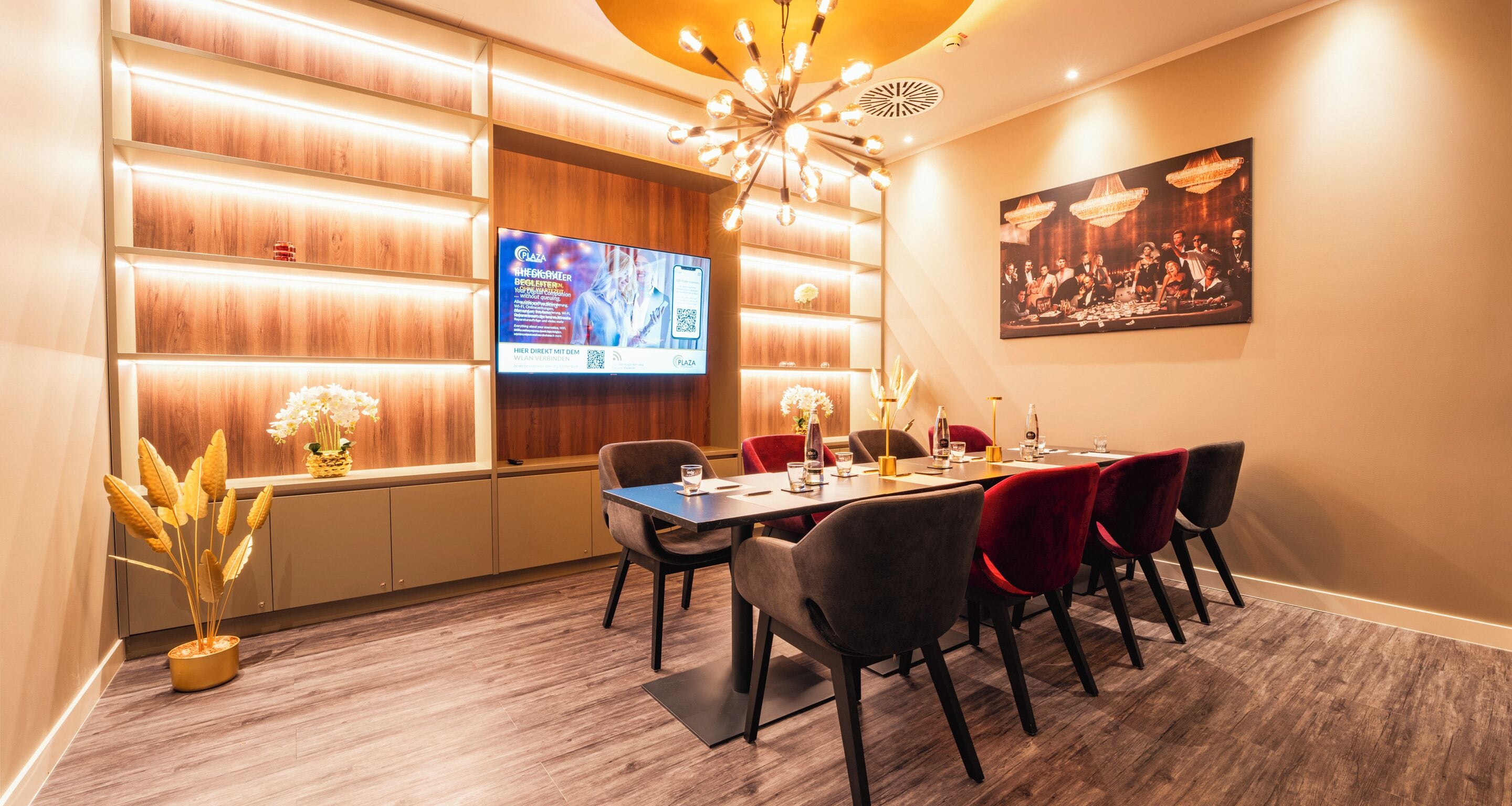 A modern dining area with a long table, multiple chairs, and a television screen displaying an advertisement.