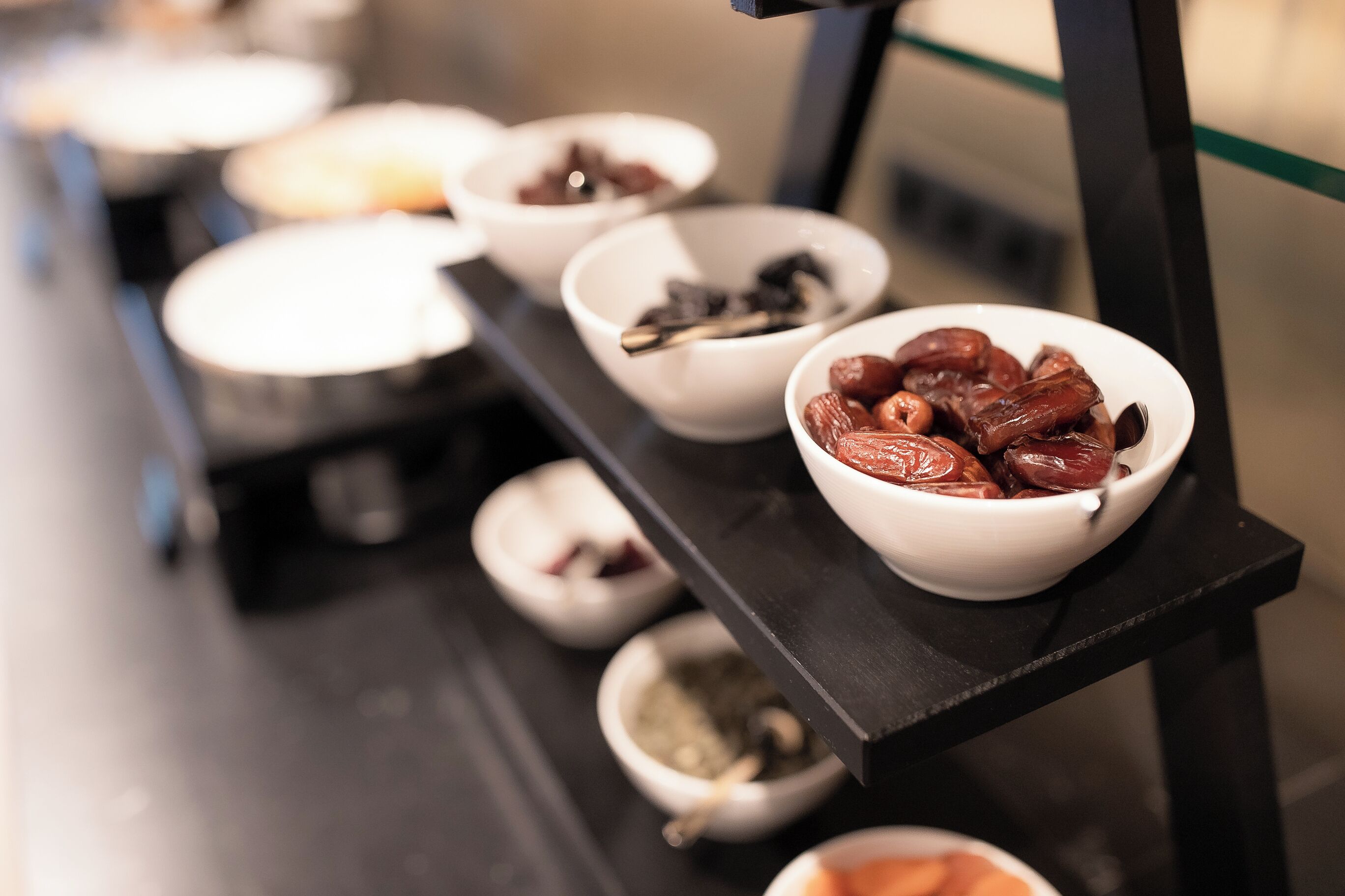 A series of bowls containing various food items on a black shelf.