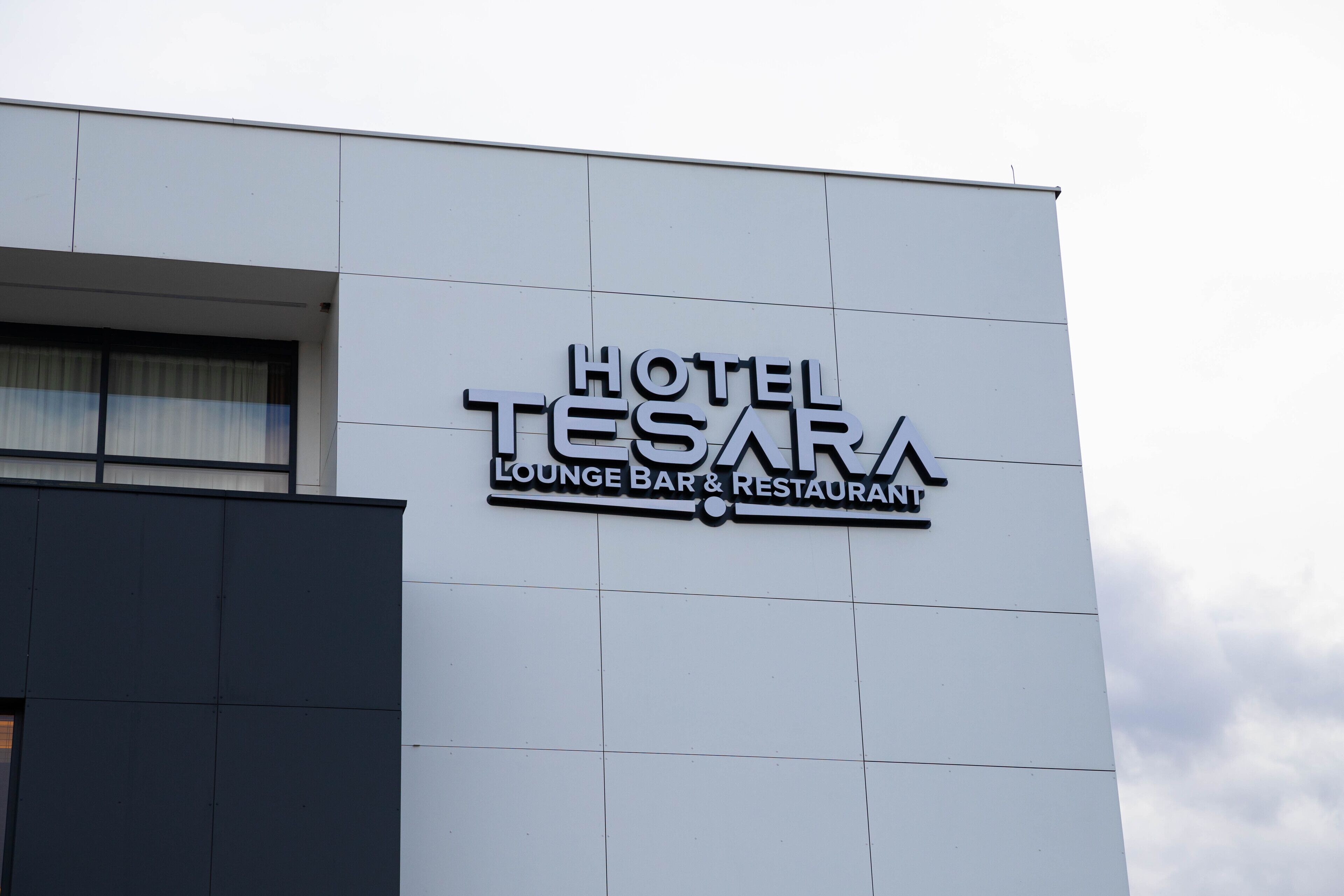 A building with a sign that reads "HOTEL TESARA LOUNGE BAR & RESTAURANT."