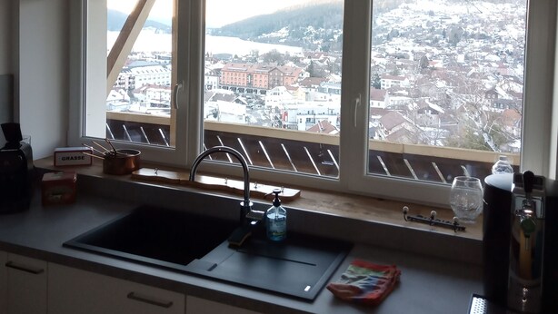 A kitchen with a large window overlooking a snowy cityscape. - CHALET ROMANE, SLEEPS 6, LAKE VIEW, AIR-CONDITIONED, BALCONY, MOTORCYCLE ROOM, GERARDMER (Gérardmer)